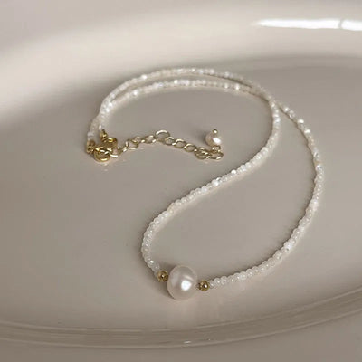 Collar perla junto a piedras naturales