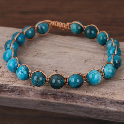 Pulsera de perlas de apatite azul tejida a mano sobre madera
